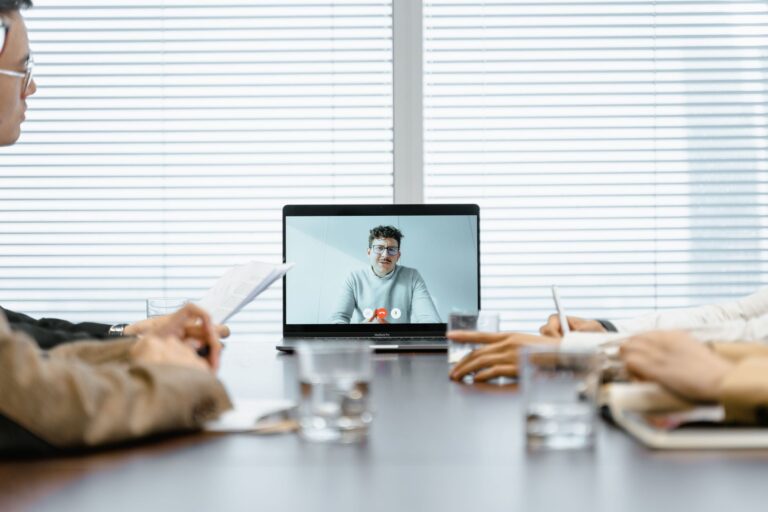 Team in einer Videokonferenz am Laptop teilt den Bildschirm