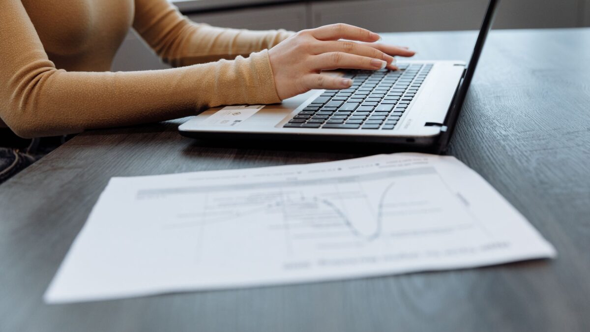 Schreibtisch im Homeoffice mit Laptop, Unterlagen und Taschenrechner