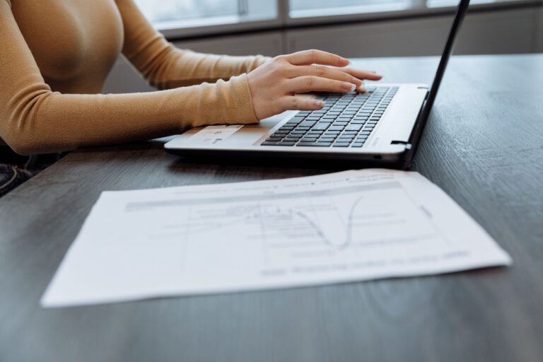Schreibtisch im Homeoffice mit Laptop, Unterlagen und Taschenrechner