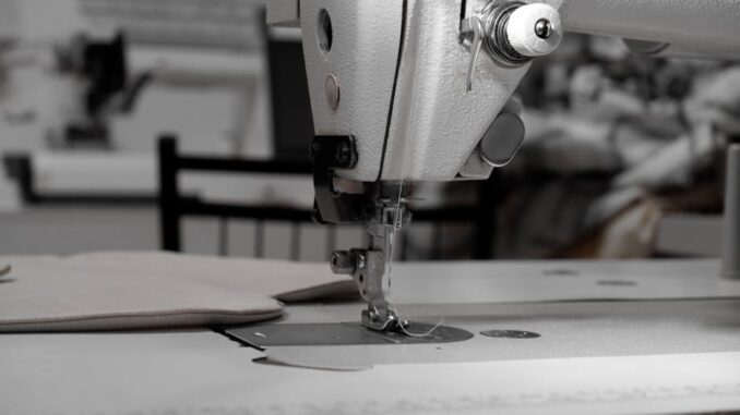 bernina - Closeup of an industrial sewing machine in a textile factory, focused on needle and fabric