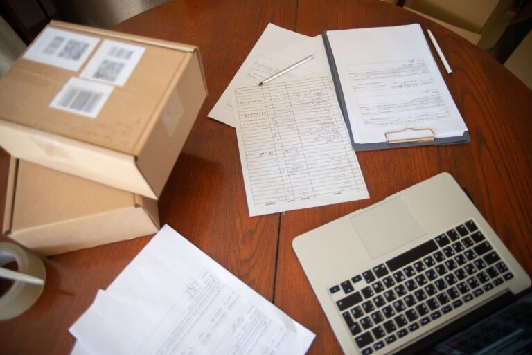 Schreibtisch im Homeoffice mit Laptop, Kontoauszügen und Notizblock