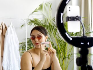 imke riedebusch - Fashion vlogger showcasing a cosmetic product with a smartphone and ring light set