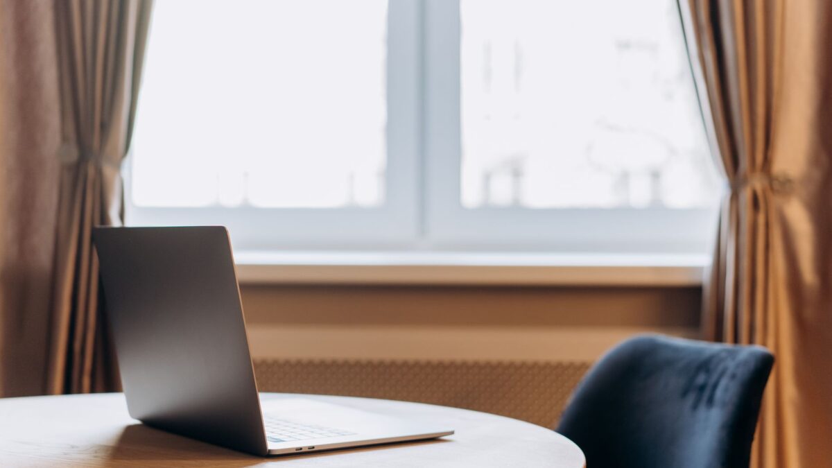 Arbeitsplatz mit Notebook und zweitem Bildschirm in einer Wohnung am Fenster