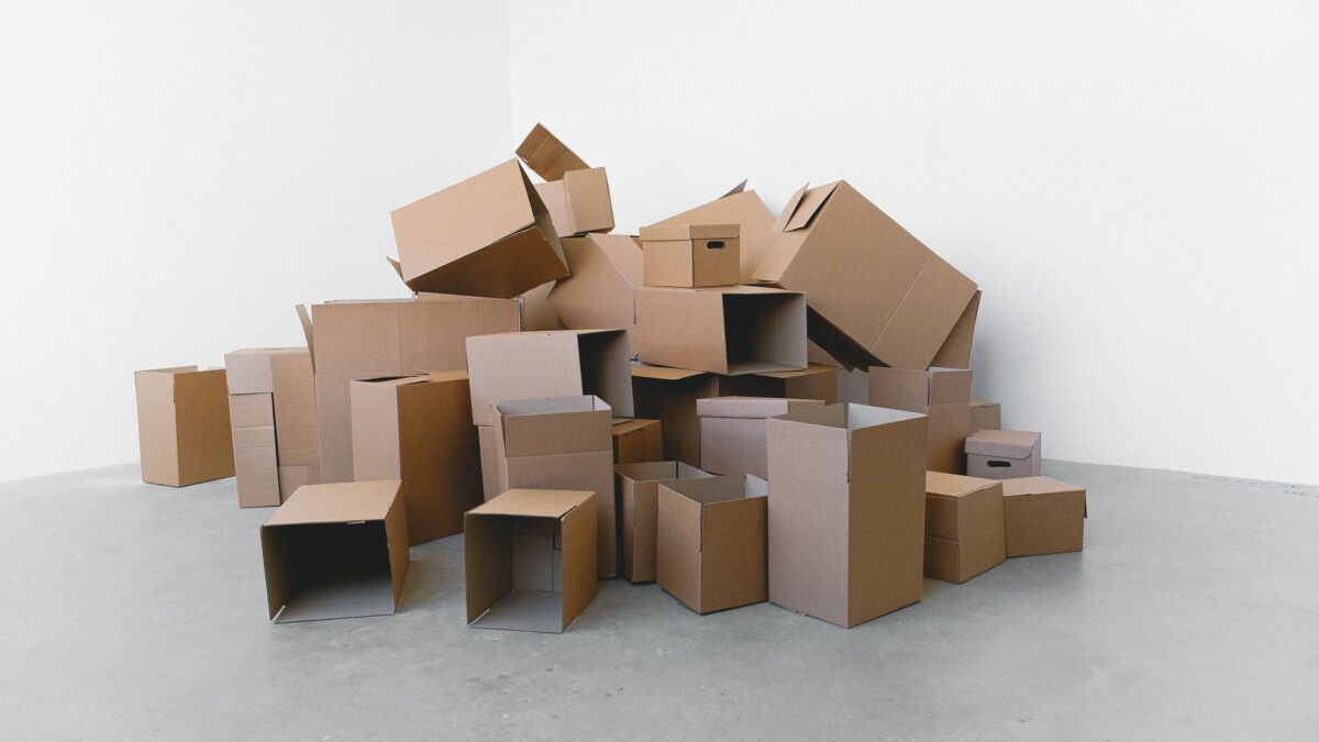 Umzugskartons neben einem abgebauten Schreibtisch im leeren Arbeitszimmer
