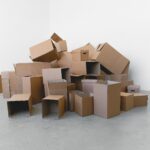 Umzugskartons neben einem abgebauten Schreibtisch im leeren Arbeitszimmer