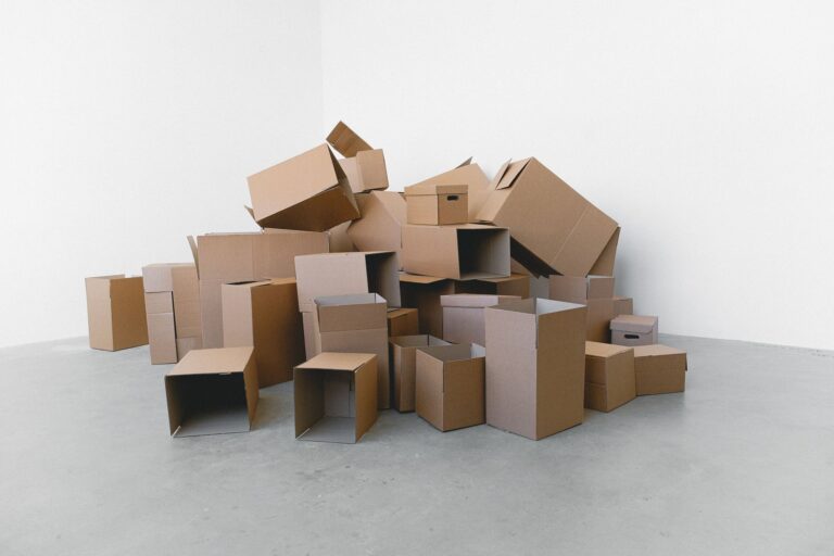 Umzugskartons neben einem abgebauten Schreibtisch im leeren Arbeitszimmer