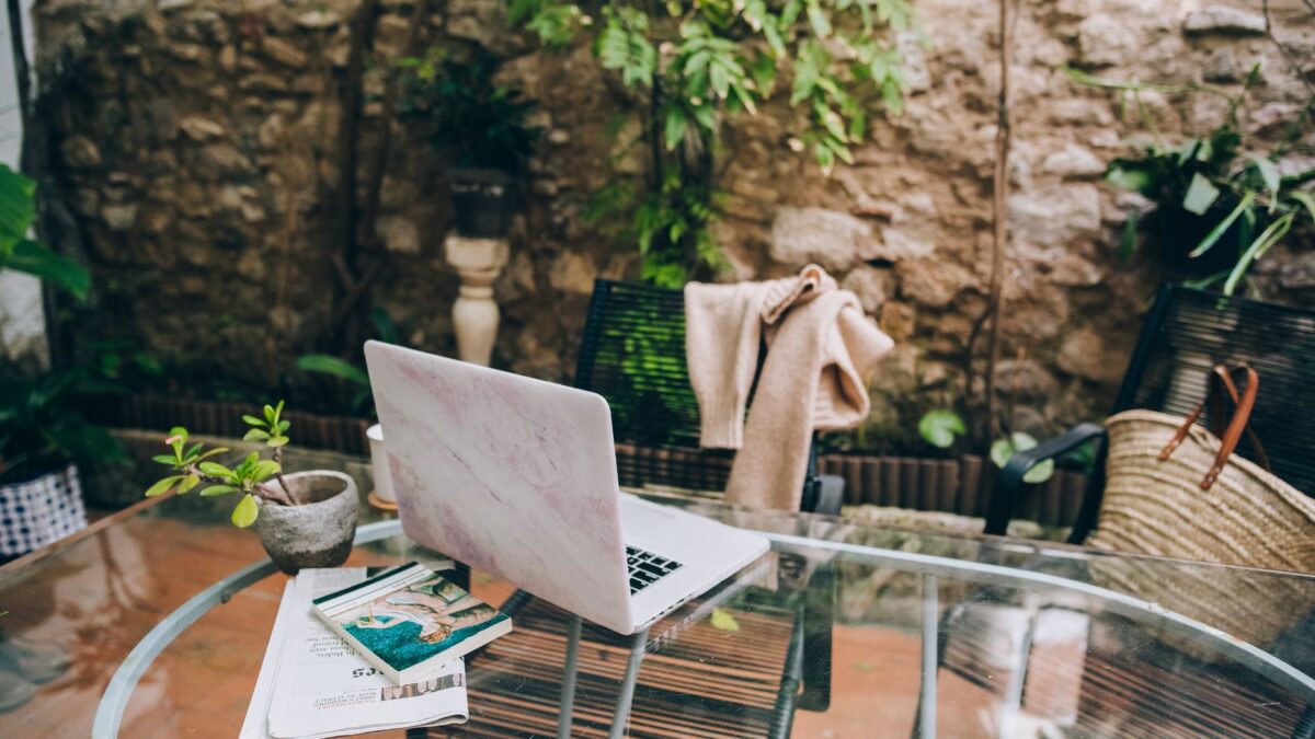 Überdachte Terrasse mit Tisch und Laptop als Arbeitsplatz im Freien